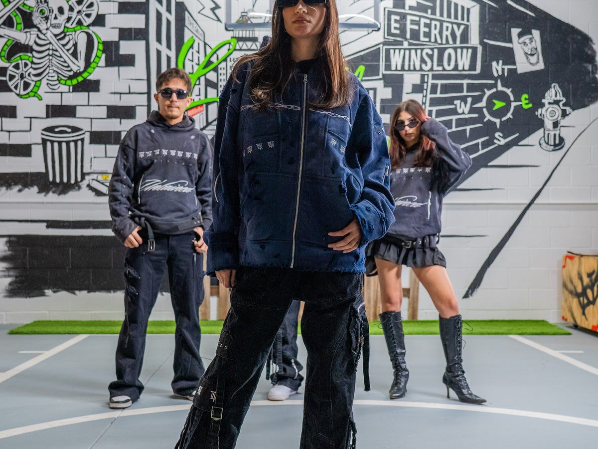 Three models wearing UNTAINED Winter 2026 in front of a painted wall